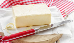 Butter mit Messer auf Brett