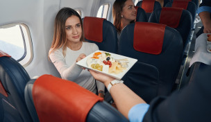 Junge Frau erhält im Flugzeug ihre Mahlzeit