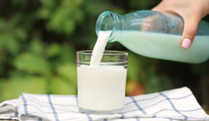 Milch wird aus einer Flasche in ein Glas gegossen Milch wird aus einer Flasche in ein Glas gegossen