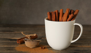 Eine Tasse voller Zimtstangen auf einem Tisch Eine Tasse voller Zimtstangen auf einem Tisch