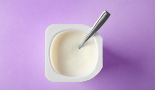 Plastikbecher mit Joghurt auf farbigem Hintergrund ©belchonock