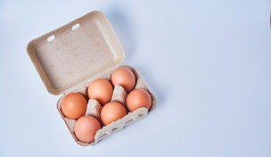 Sechs Eier in Papier-Box auf weißem Hintergrund