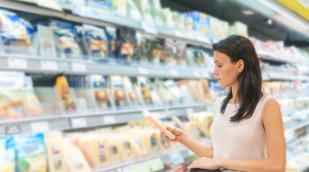 Frau liest eine Käseverpackung Frau liest eine Käseverpackung