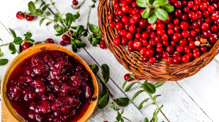 Preiselbeerenmarmelade neben frischen Preiselbeeren auf einem Tisch Preiselbeerenmarmelade neben frischen Preiselbeeren auf einem Tisch