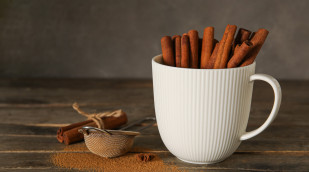Eine Tasse voller Zimtstangen auf einem Tisch Eine Tasse voller Zimtstangen auf einem Tisch