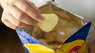 Hand mit Tüte und Kartoffelchips Hand mit Tüte und Kartoffelchips