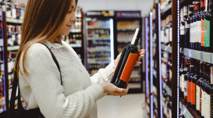 Frau betrachtet Weinflaschen Frau betrachtet Weinflaschen