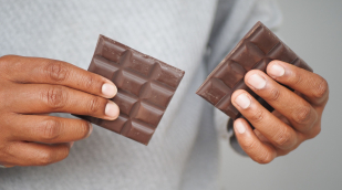 Mann hält eine Schokoladentafel Mann hält eine Schokoladentafel