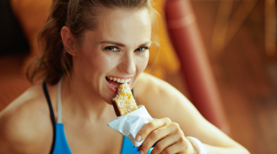 Sportlerin isst Proteinriegel Sportlerin isst Proteinriegel