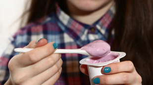 Person isst Fruchtjoghurt Person isst Fruchtjoghurt