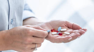 Person hält verschiedene Kapseln und Tabletten in der Hand Person hält verschiedene Kapseln und Tabletten in der Hand